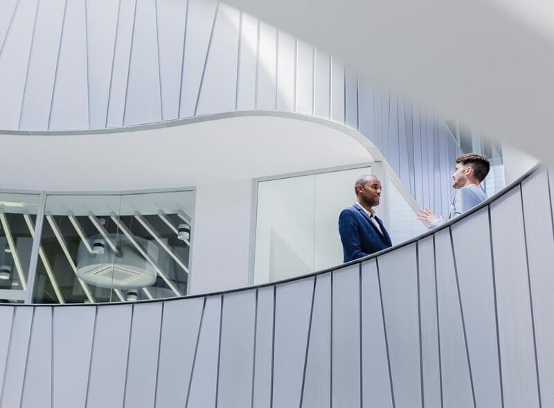 Businessmen talking on architectural, modern office balcony